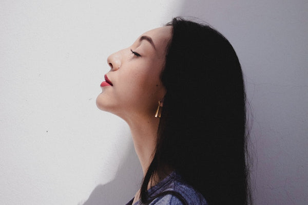 Profile of a young, dark haired woman looking up