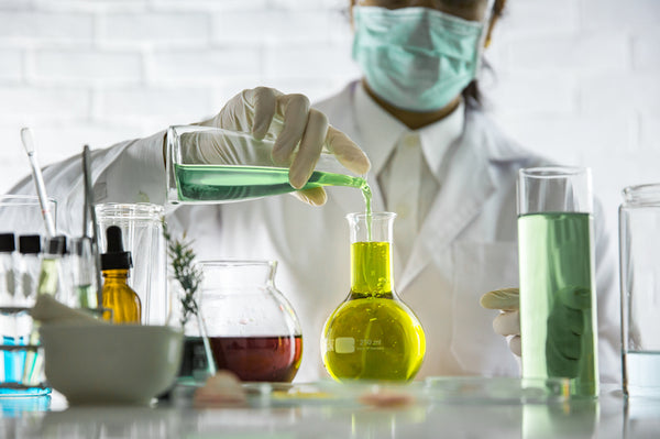 Scientist sampling a chemical extract, research and develop background for health & beauty care.