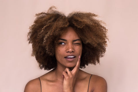 Woman with curly hair thinking