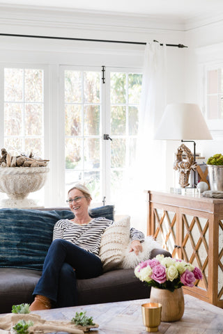 Hilde laughing, sitting on her couch in her living room