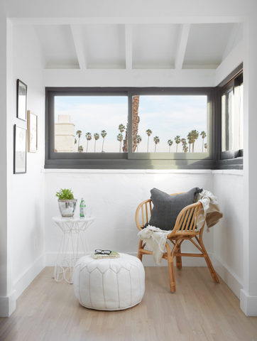 a small sitting area with a chair and windows