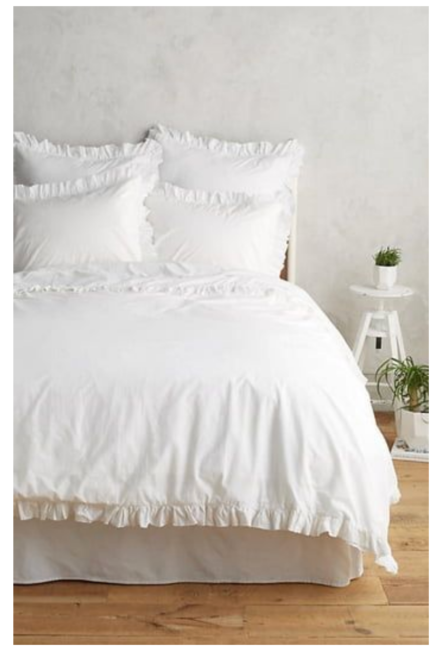 White ruffle bedding on a bed