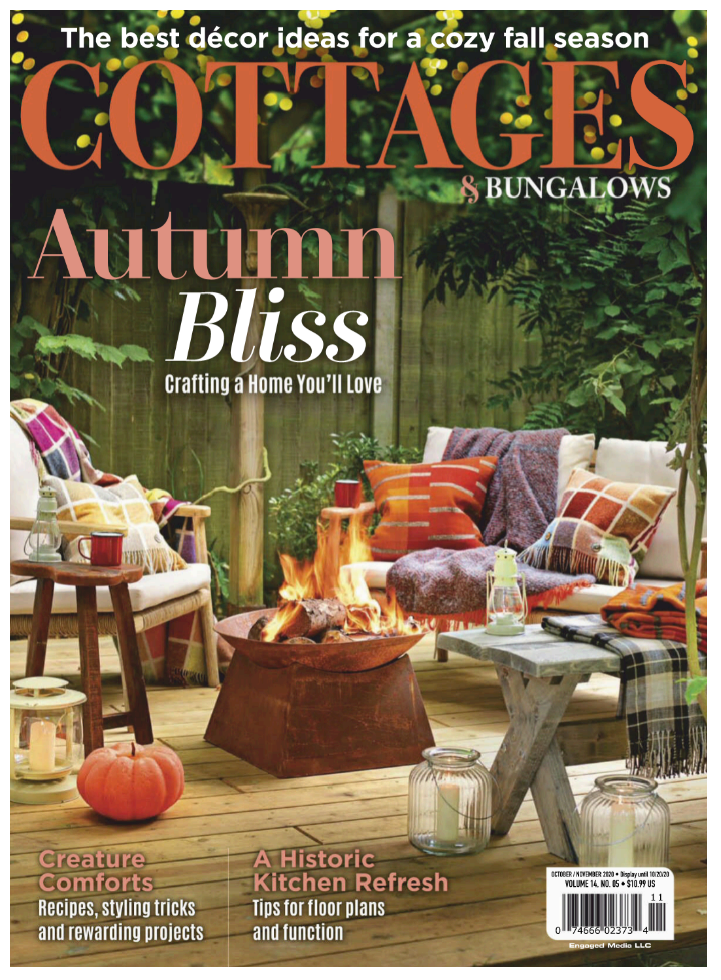 The cover of Cottages and Bungalows magazine, a bonfire on a wooden deck outside with chairs and blankets around.
