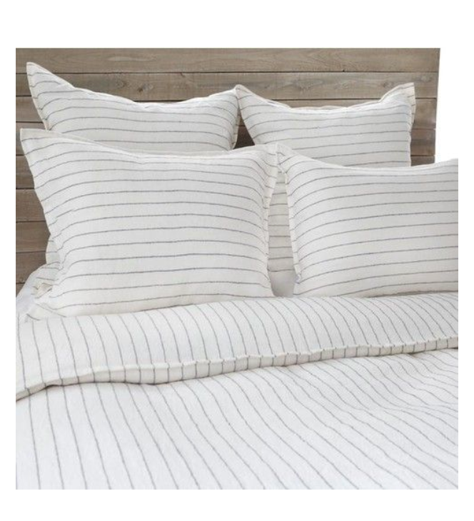 A bed with a striped duvet and four pillows.