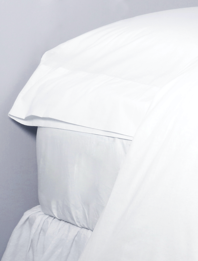 simple white bed made with cotton percale sheets