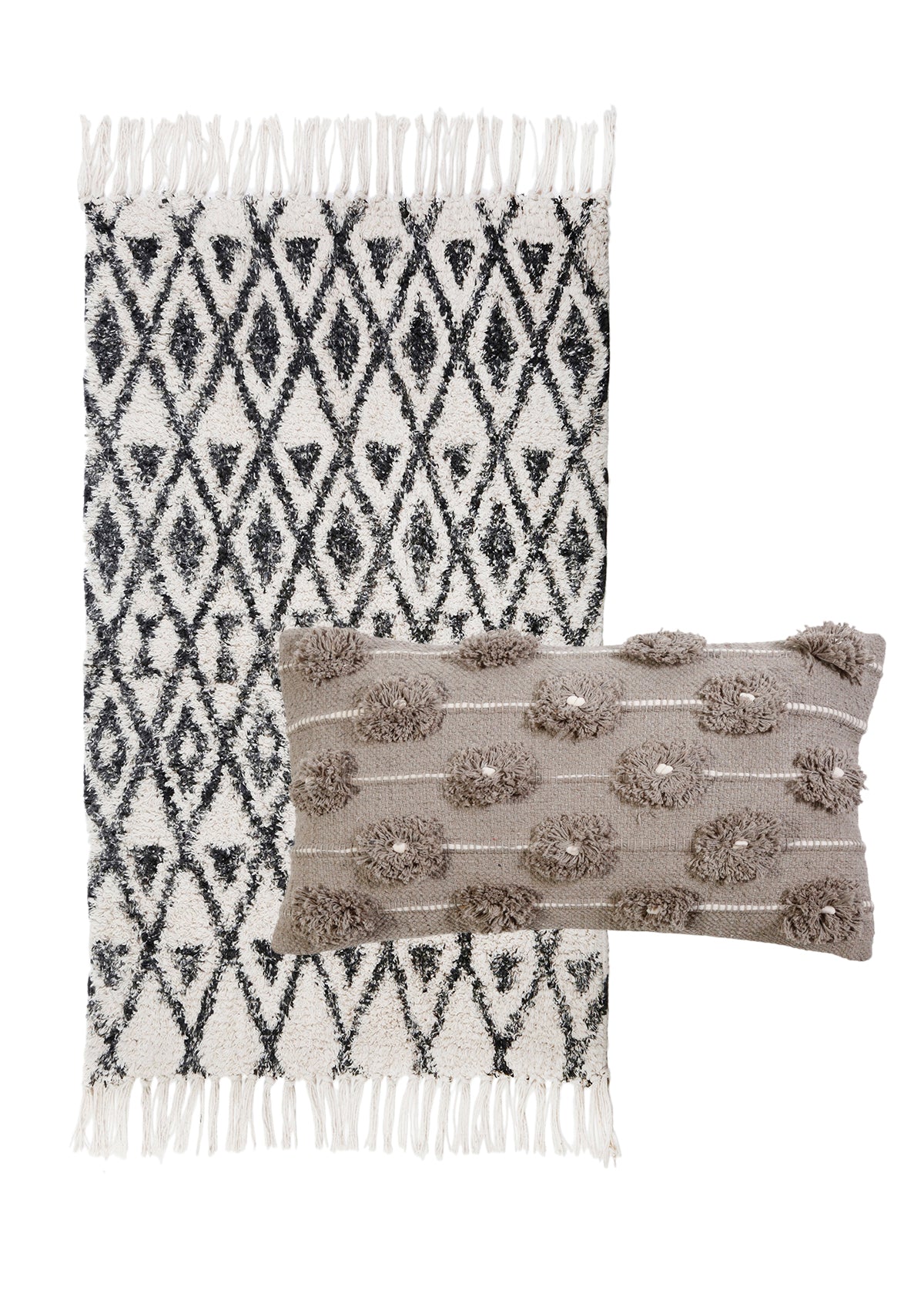 A black and ivory rug with tassels and diamond patterns, with a small pillow in the front. Brown with tassels