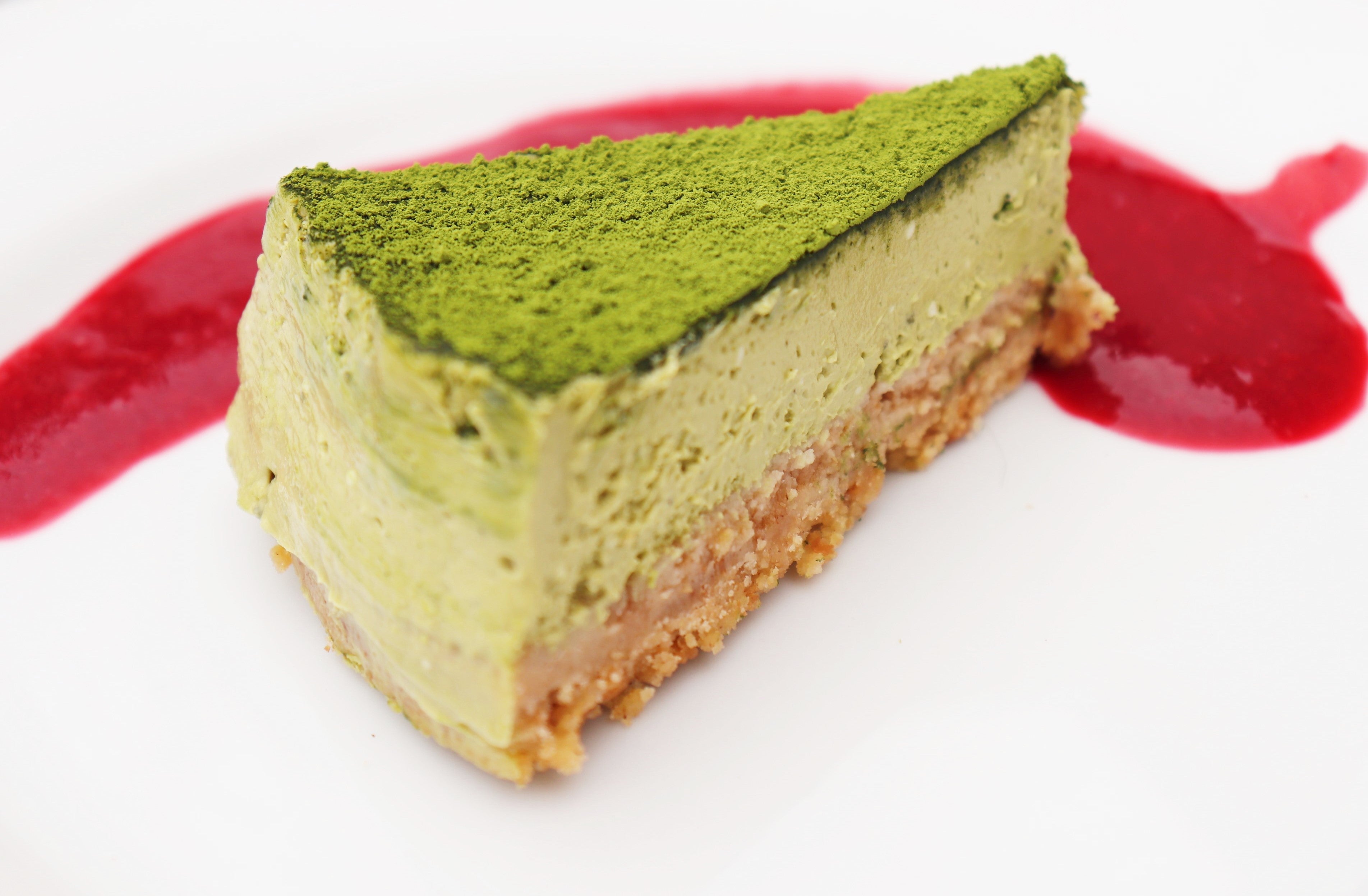 part de cheesecake au matcha bio et coulis de fruits rouges