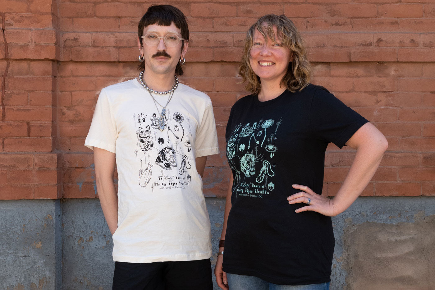 Leaf and Danielle are wearing the 17th Anniversary T-shirts  in front of a brick way. Leaf wears the t-shirt in white while Danielle wears the black colored t-shirt.