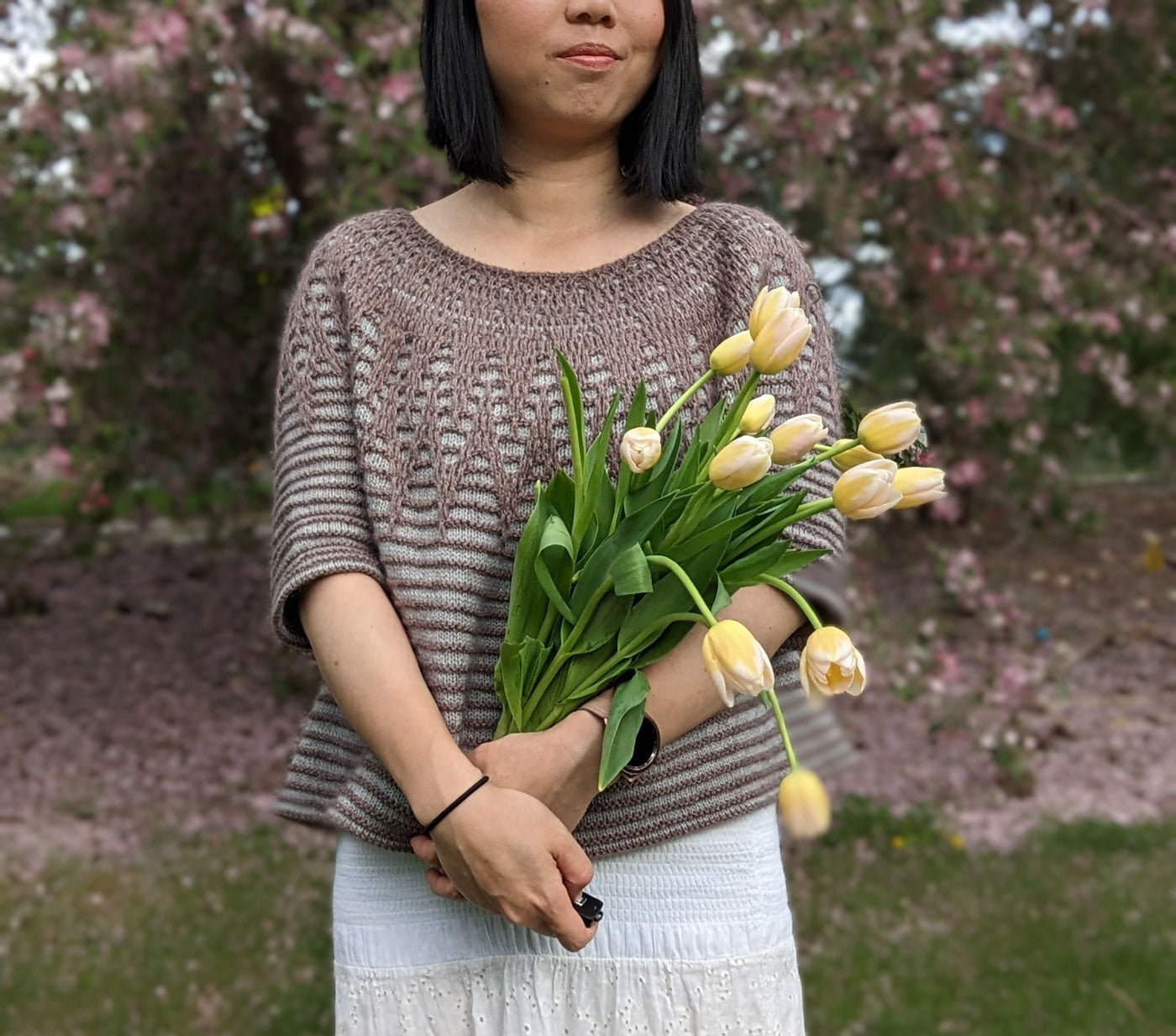 This is a close up shot of Connie wearing her Aubade pullover while cradling a bouquet of tulips.  