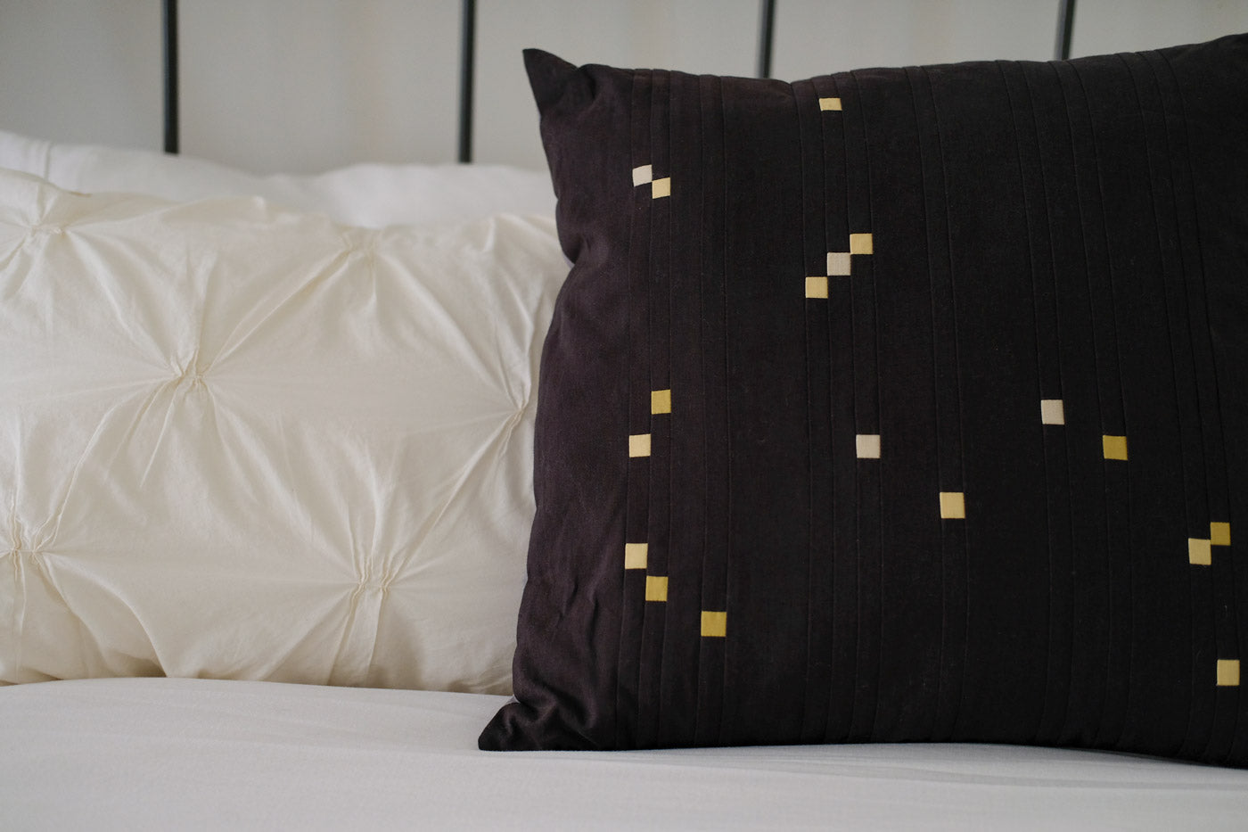 Constellations Book Orion quilted pillow sitting on a white bed