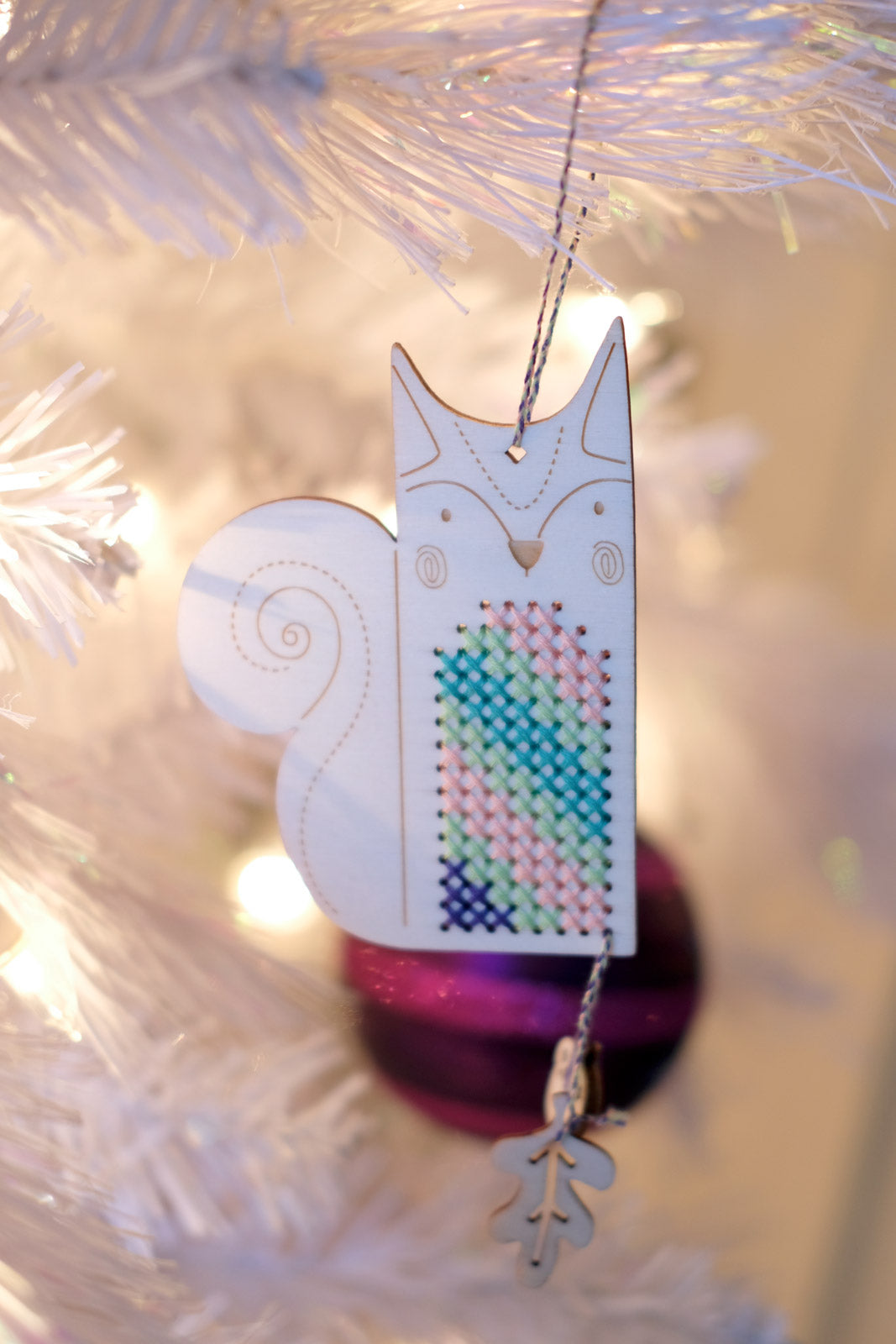 Stuart the Squirrel Crafty Like a Fox ornament hanging on a white tree