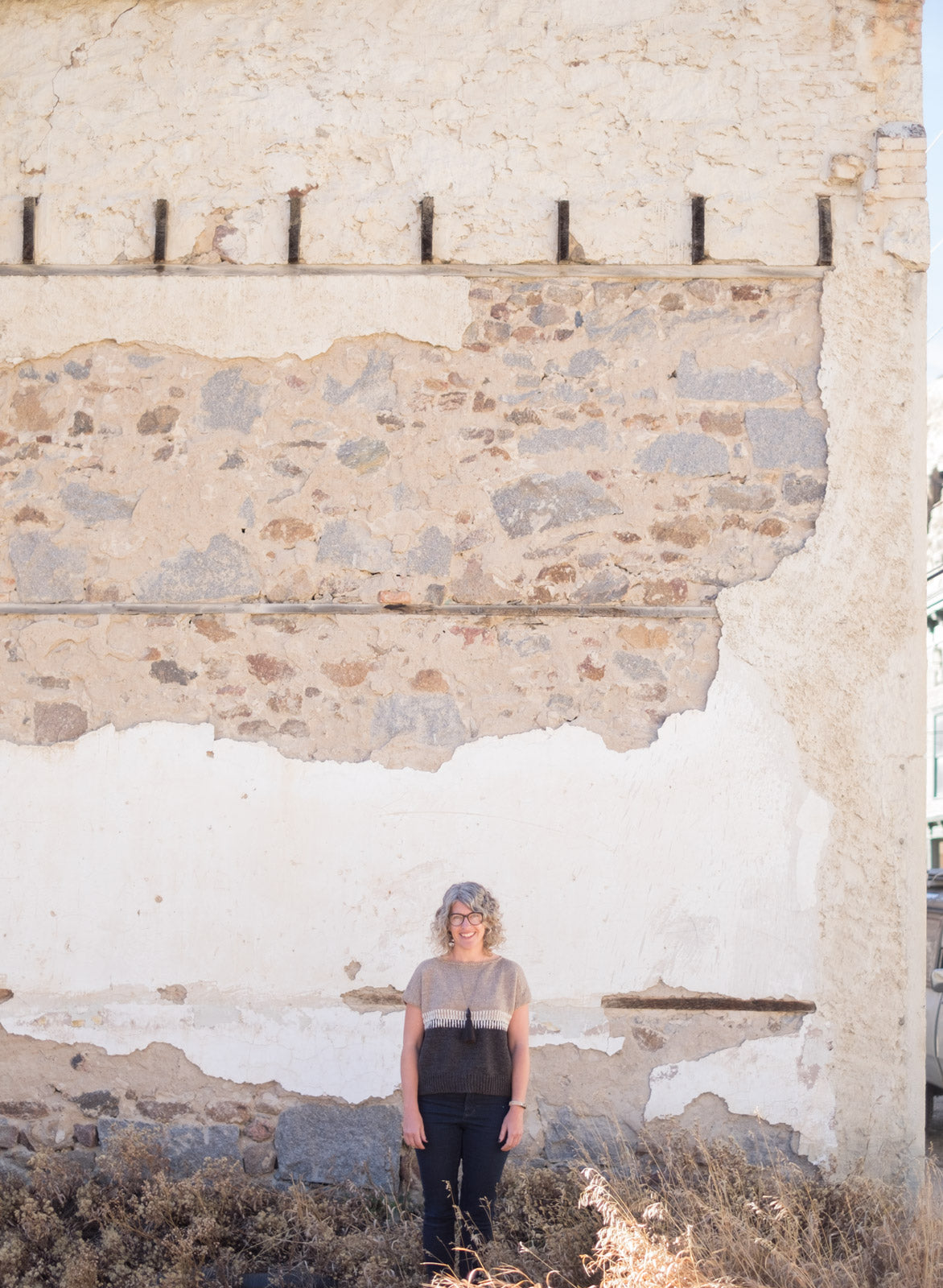 Jaime standing in front of a stone and white wall in her Fukuro Pullover