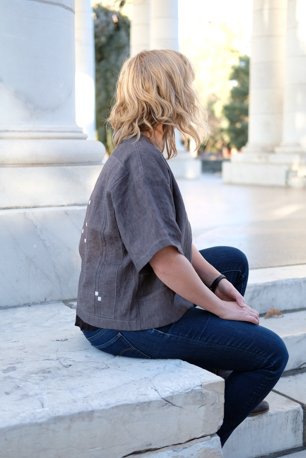 Amber Corcoran sitting with her back to the camera showing off her Constellations Hoshi Jacket