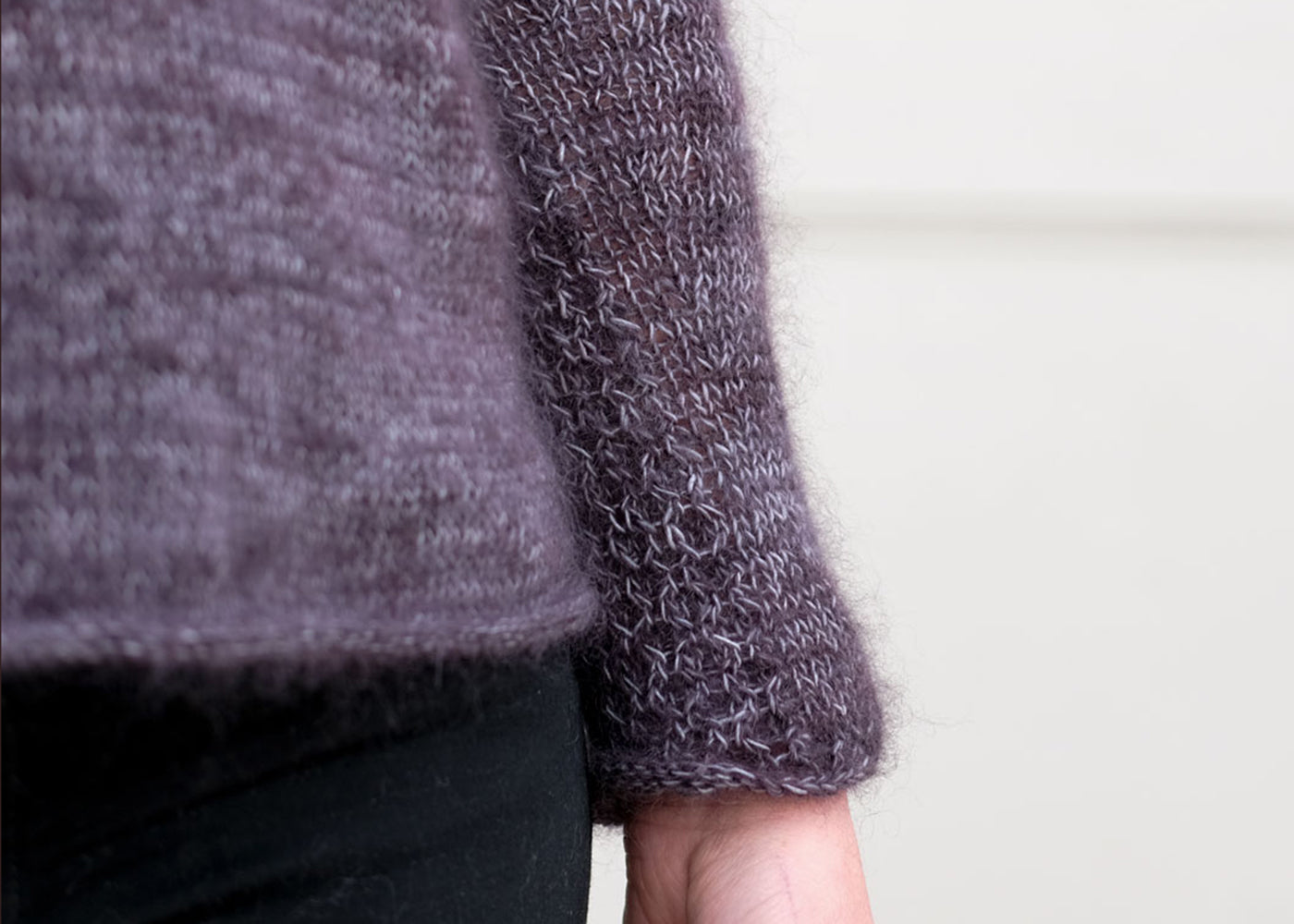 A close up of the hem and sleeve on a marled yarn soiree sweater