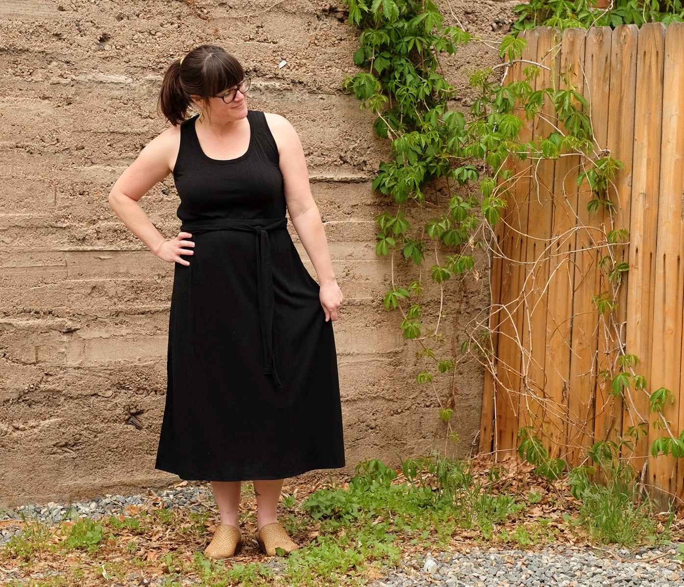 Amanda's standing in front of brick wall in handsewn maxi dress