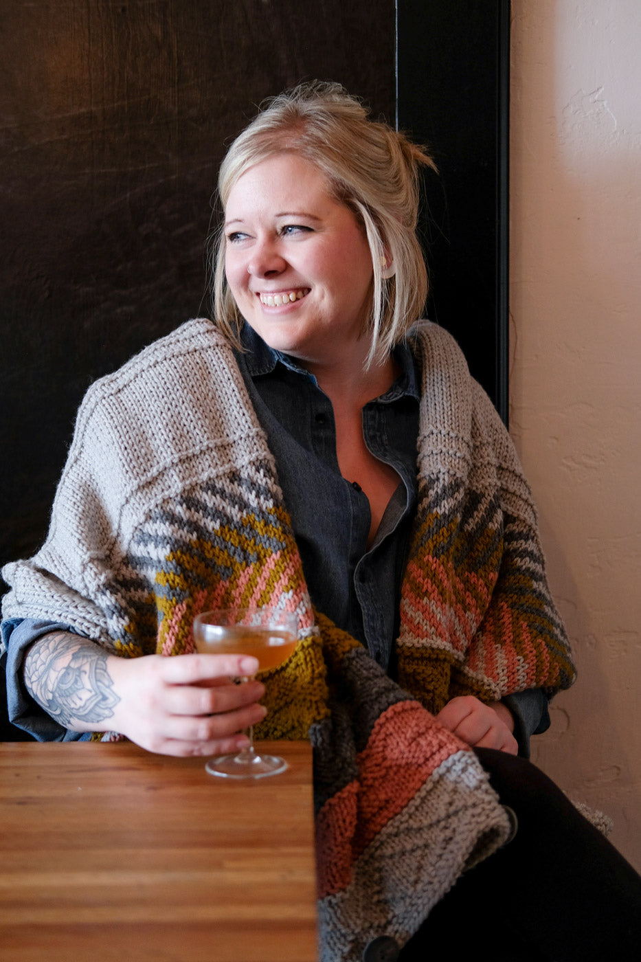 Heather sipping a cocktail in her Om shawl