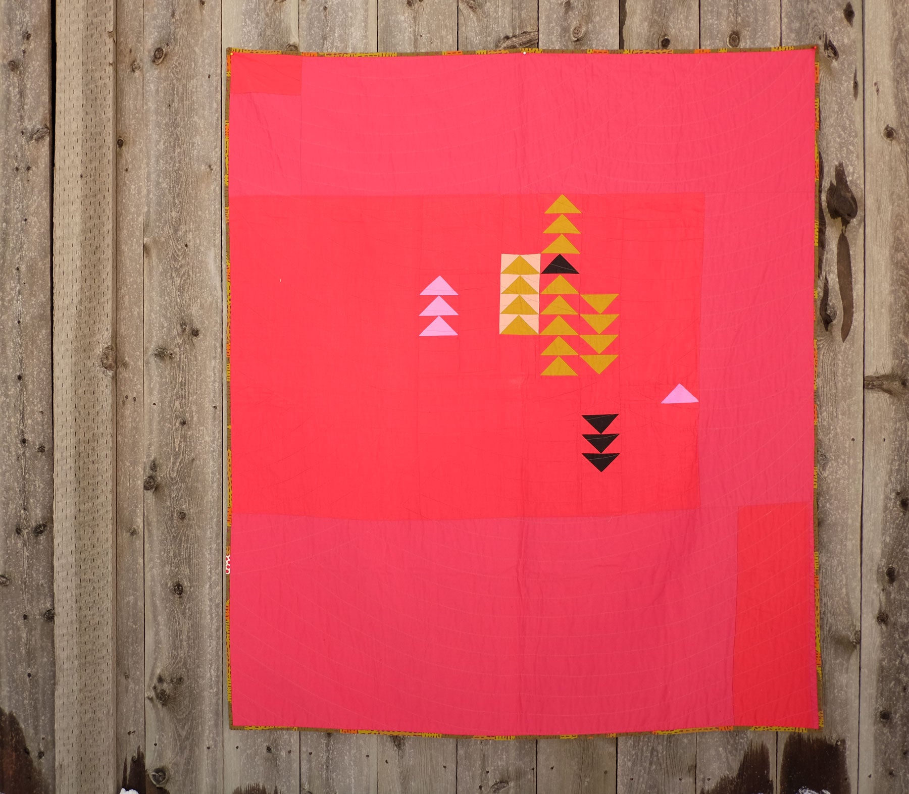 Shawna Doering's Red Hot Quilt hanging on a fence