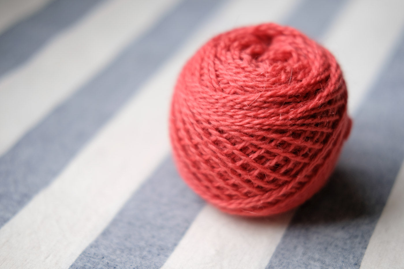 A small ball of Kelbourne Woolens Andorra in a salmony-pink color