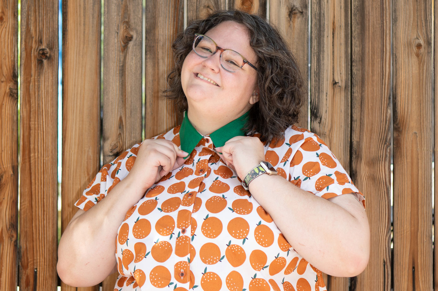 This is a close up shot of Kim holding the ends of the green collar of her shirt.