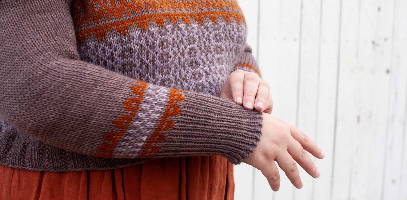 This is a close up image of Kim's Mozaika Sweater, focused on the colorwork design on the front and sleeves of the sweater. 
