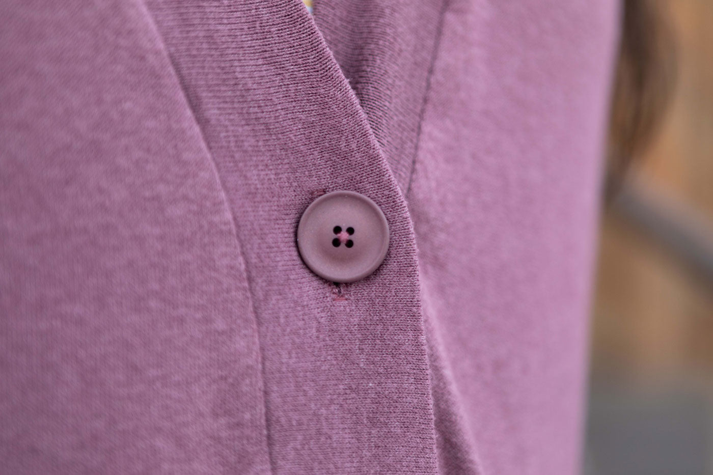 This is image of a close up on the Recycled Poly 25 mm button in Dusty Pink on Kim's cardigan