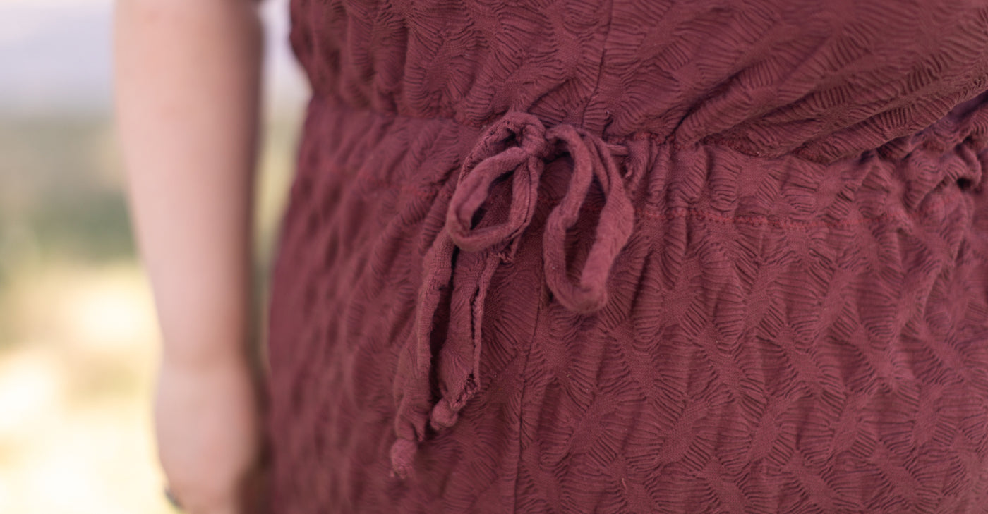 this is a photo up close of a drawstring waistband in mauve knit fabric