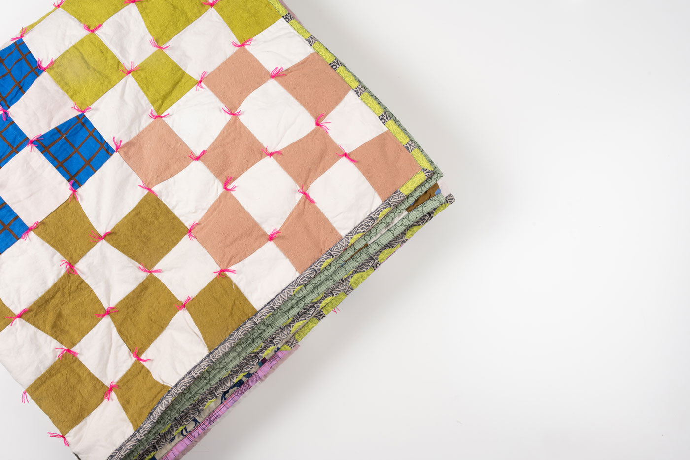 Shawna's Omega Quilt is folded into a square in front of a white background