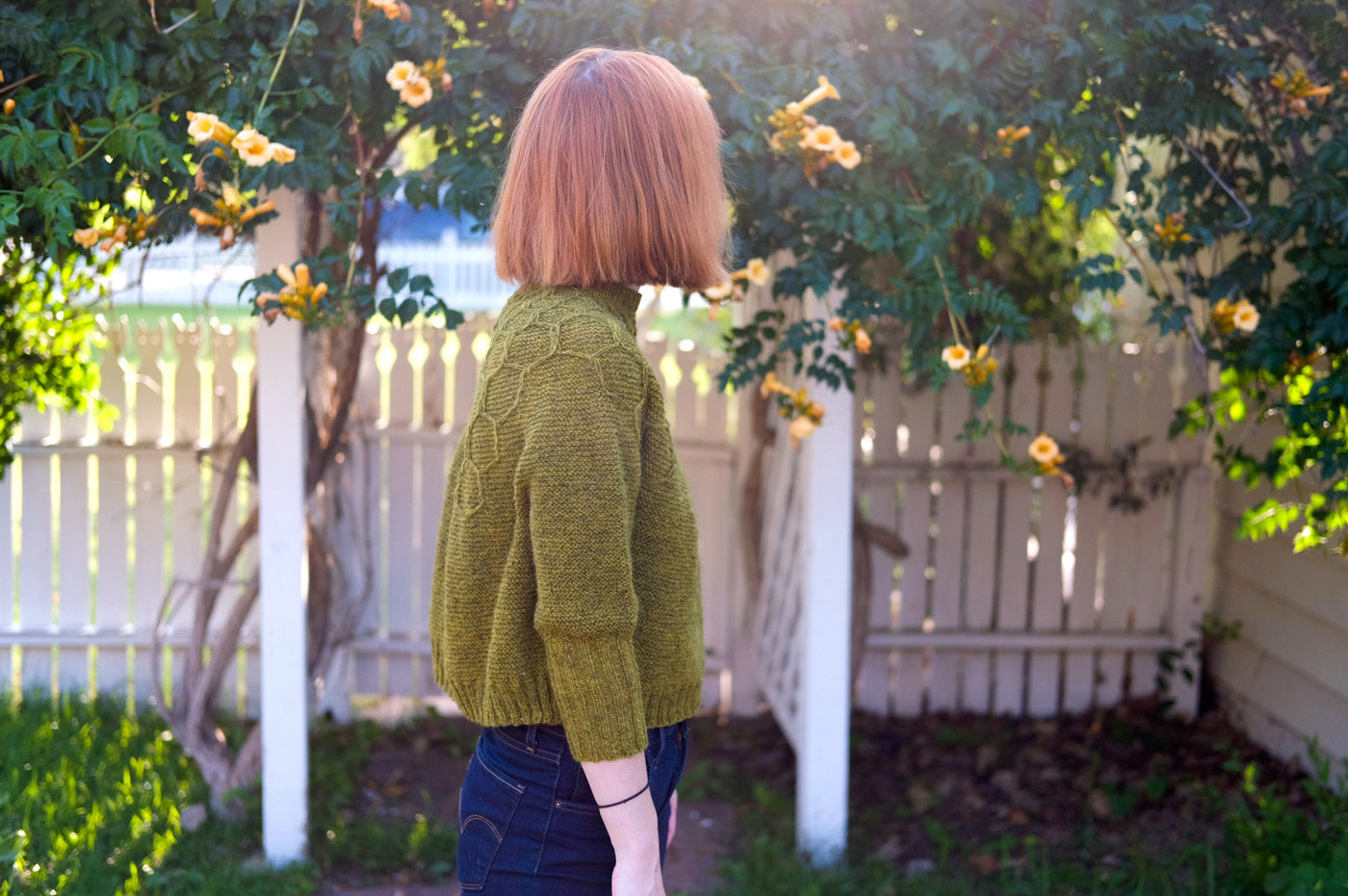 Lauren in her garden wearing her Wool and Honey Sweater