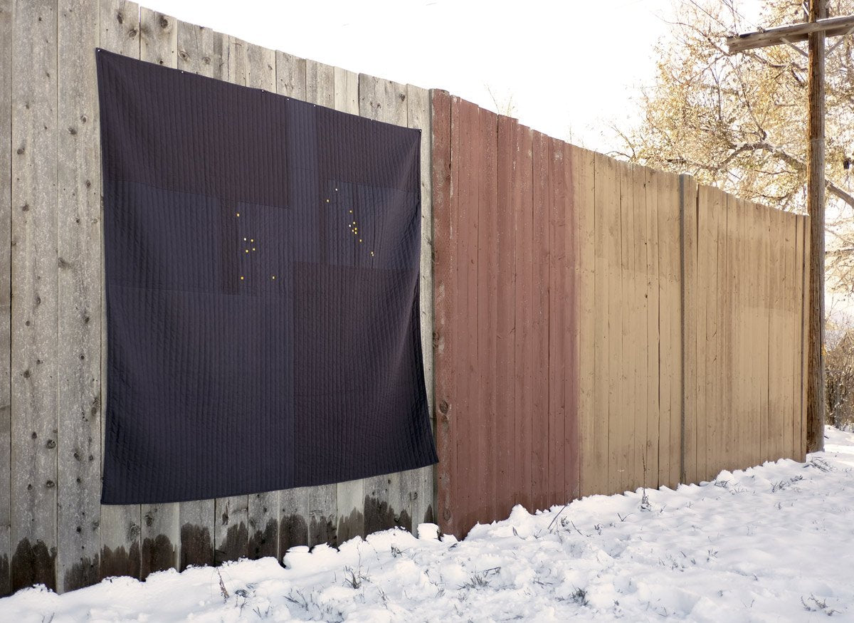 Constellation Quilt Hanging on a wooden fence