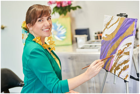 Artist and fashion designer Alesia Chaika painting the artwork in acrylics and gold foil application the "Purple Road" at her art studio in Buffalo Grove, IL USA