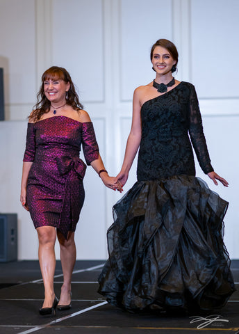 Chicago Fashion Designer Artist Couturier Alesia Chaika in her custom purple triangle jacquard gown with bean neckline presenting Black Rose mermaid evening lace organza dramatic skirt gown at Model icon Fashion Week Palmer House Hilton Hotel Chicago