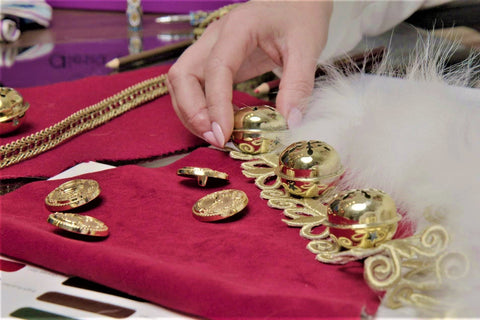 Crafting the traditional Santa Claus costume with gold jingle bells, white fur, red velvet at Alesia Chaika atelier located in Buffalo Grove, Illinois USA