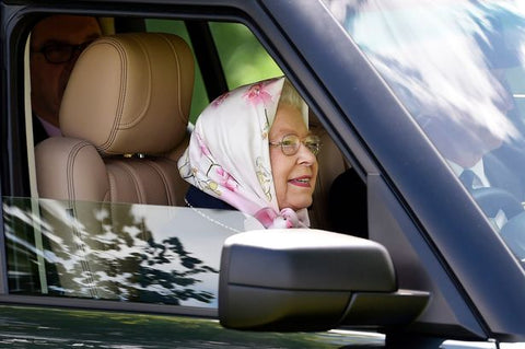 Queen driving a car with a headscarf on