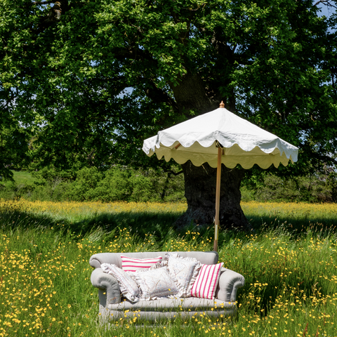 Holly Octagonal Parasol in a field with a couch
