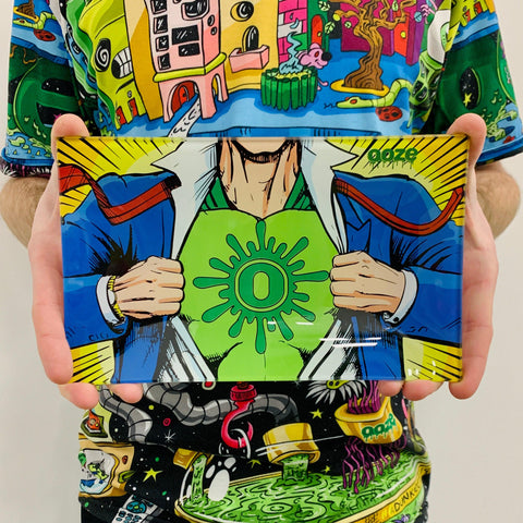 A white male holds the Captain O Ooze Shatter-Resistant Glass Rolling Tray in both hands. He is wearing a shirt with the Oozeville design printed all over.