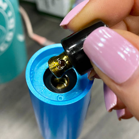 Removing a dirty Onyx Atomizer from a blue Booster. There is sticky concentrate residue covering the atomizer threads.