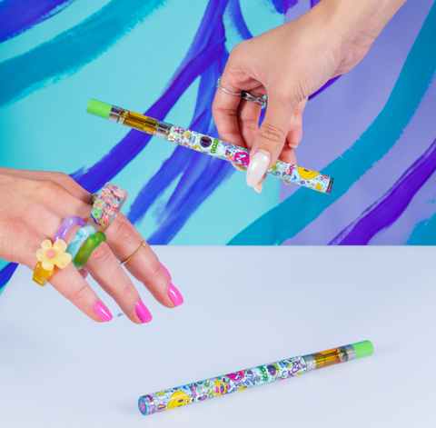 Two girls' hands are reaching for their own Chroma Ooze Twist Slim Pen 2.0s