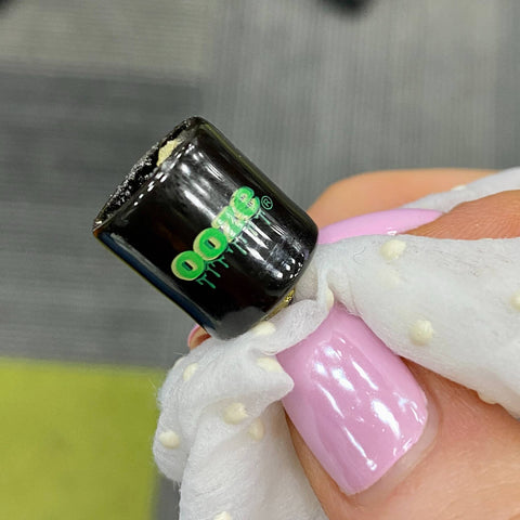 Using a Res Wipe to clean the dirty threads of an Ooze Onyx Atomizer.