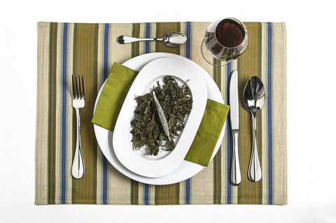 An overhead shot of a table setting with the top dish filled with cannabis nugs and a joint.