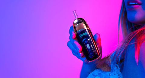 The Ooze Flare dry herb vaporizer is held by a girl who is out of frame. The background is neon pink.