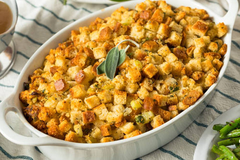 A round, white casserole dish filled with Thanksgiving stuffing