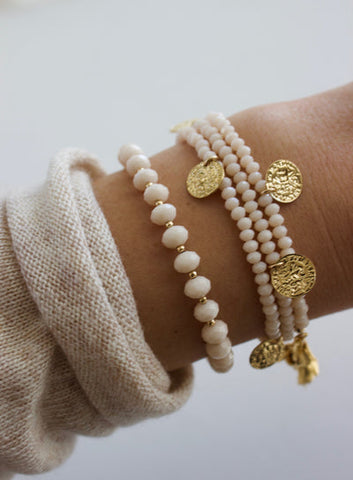 Woman's wrist with stacked pearl bracelets