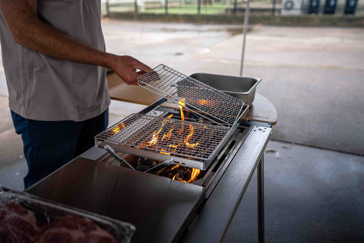 Placing the grill bridge on the Snow Peak BBQ Box in the IGT table