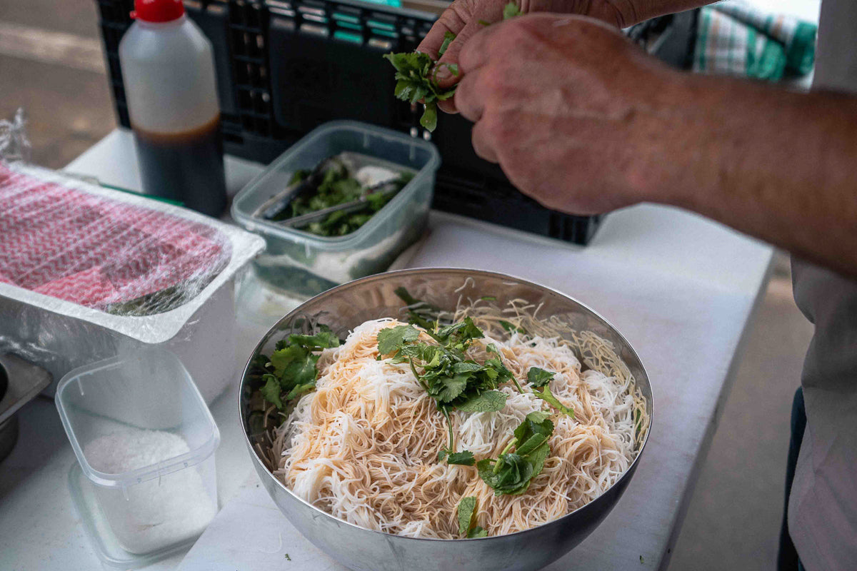Dressing the rice noodles for the grilled beef