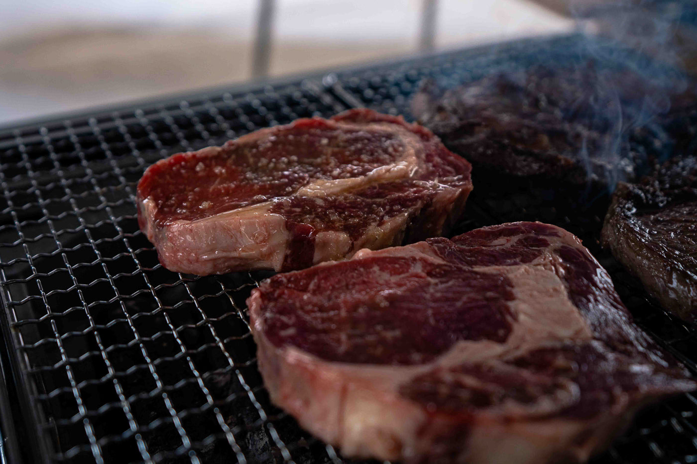 steaks being grilled on the snow peak bbq box. 