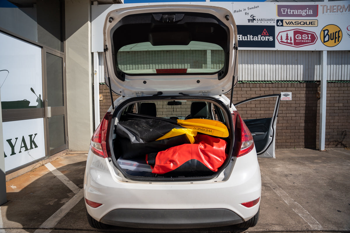 Three Kokopelli packrafts in the back of a small car