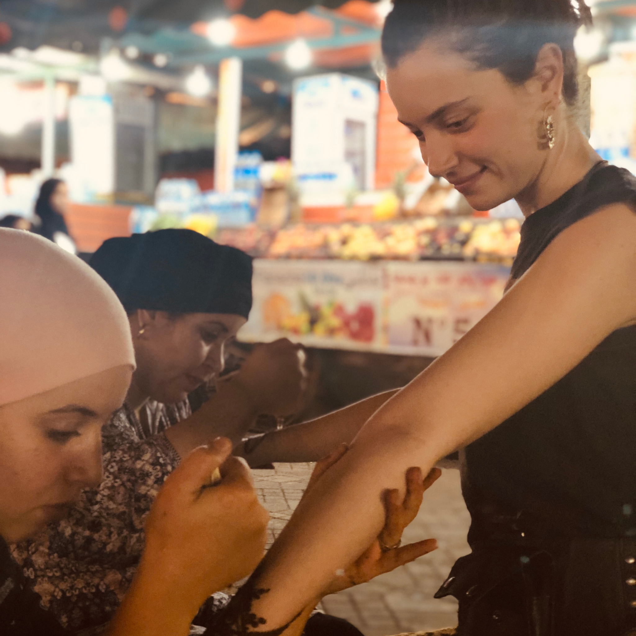 Moroccan woman doing traditional henna for a tourist in Jemaa El Fnaa Marrakech 