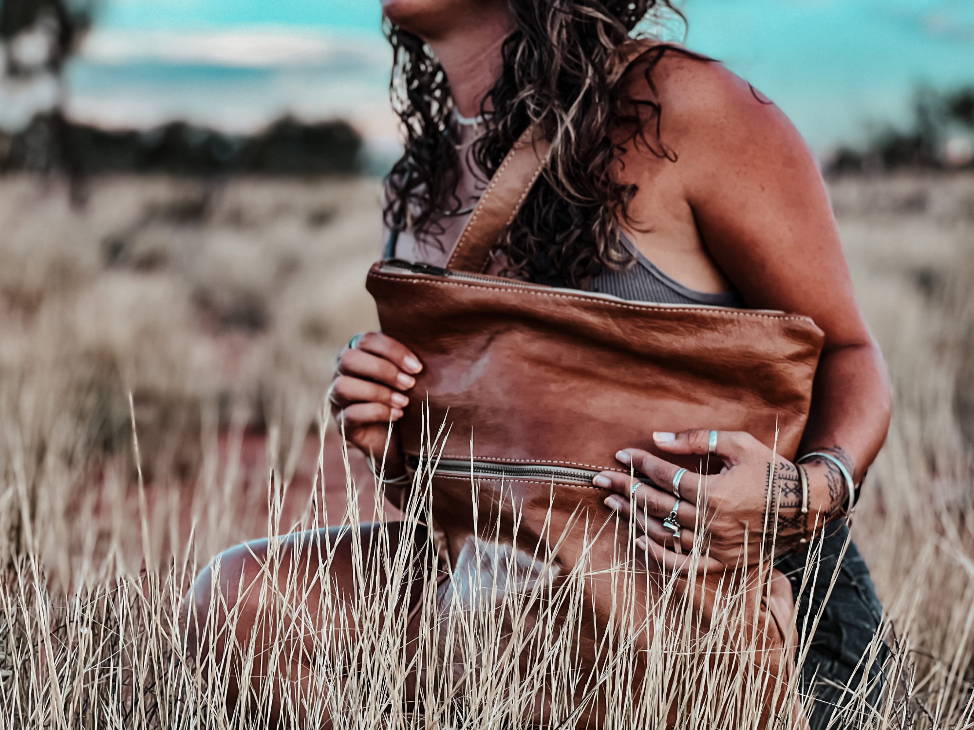 girl holding leather bag in aussie outback