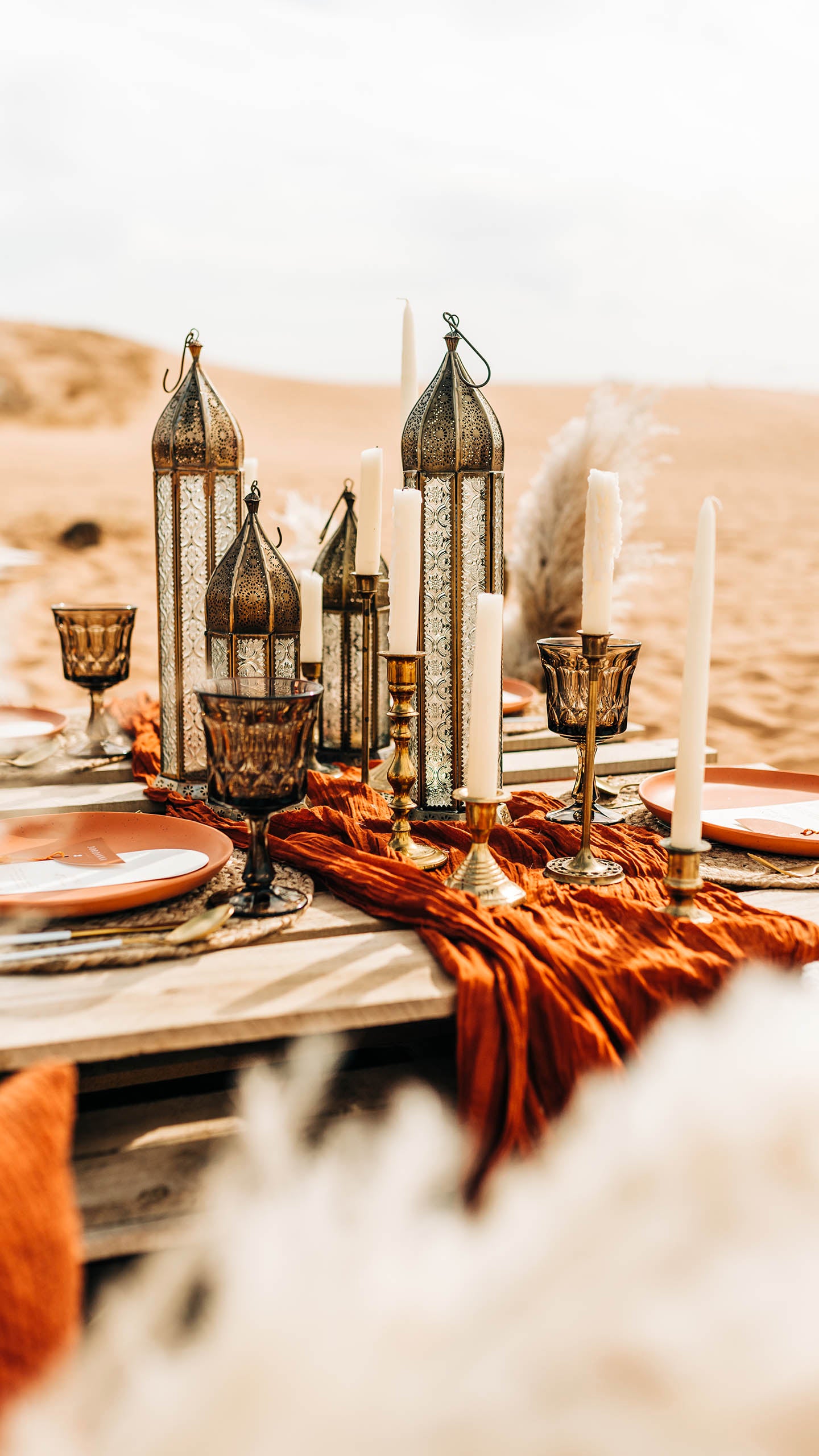 Boho Table Set Up Sitting on Sand with Blankets