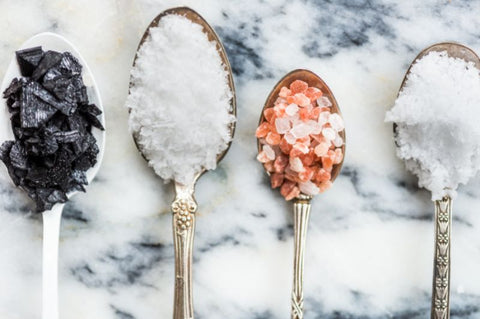 4 spoons holding 4 different kinds of salt